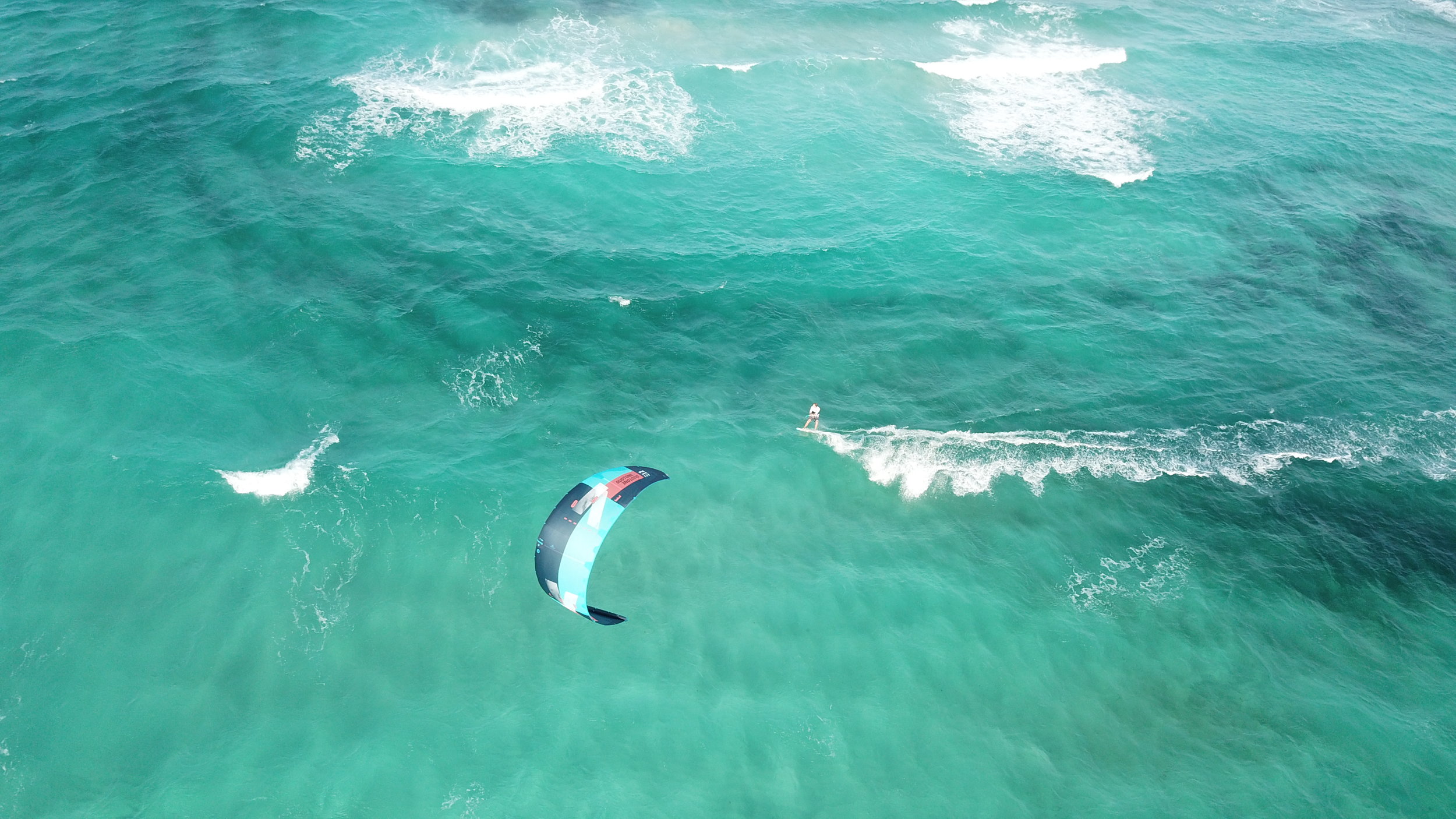 Kiteboarder moving through turquoise water